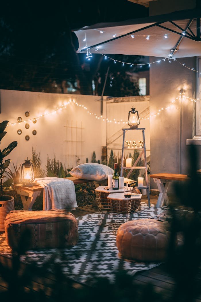gallery-04 Warmly lit outdoor patio with cozy seating, lanterns, and decorative lights.